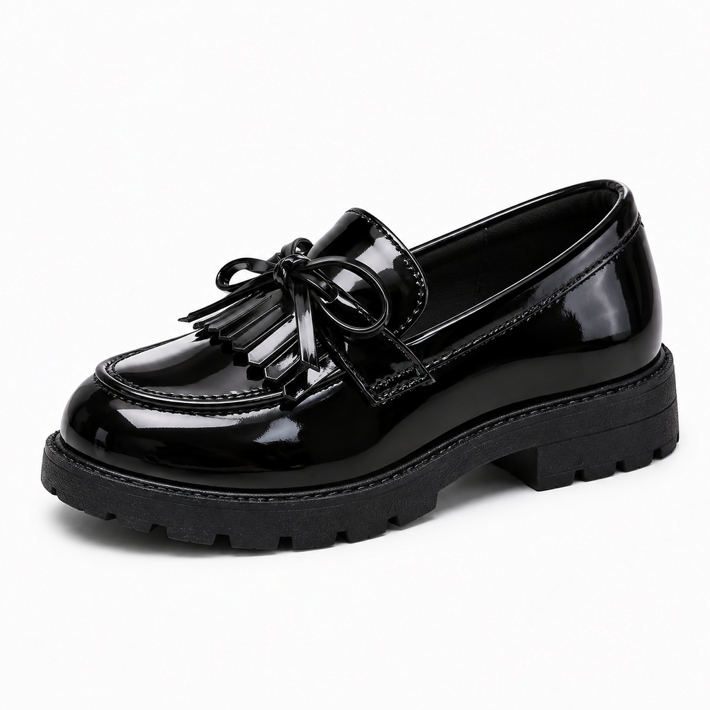 Kids Tassel Bow Loafers Black - single side view. Single side studio photo of black glossy kids tassel bow loafers with neat tassel detail, stitched apron and chunky lug sole.