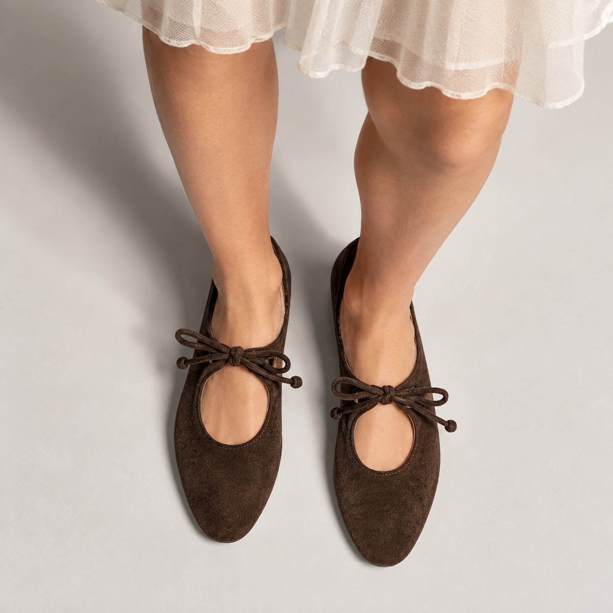 Womens Lace Up Suede Mary Jane Flats - Dark Brown worn styling. Dark Brown suede Mary Jane flats styled on foot with a feminine outfit, highlighting the bow laces and elegant flat silhouette.