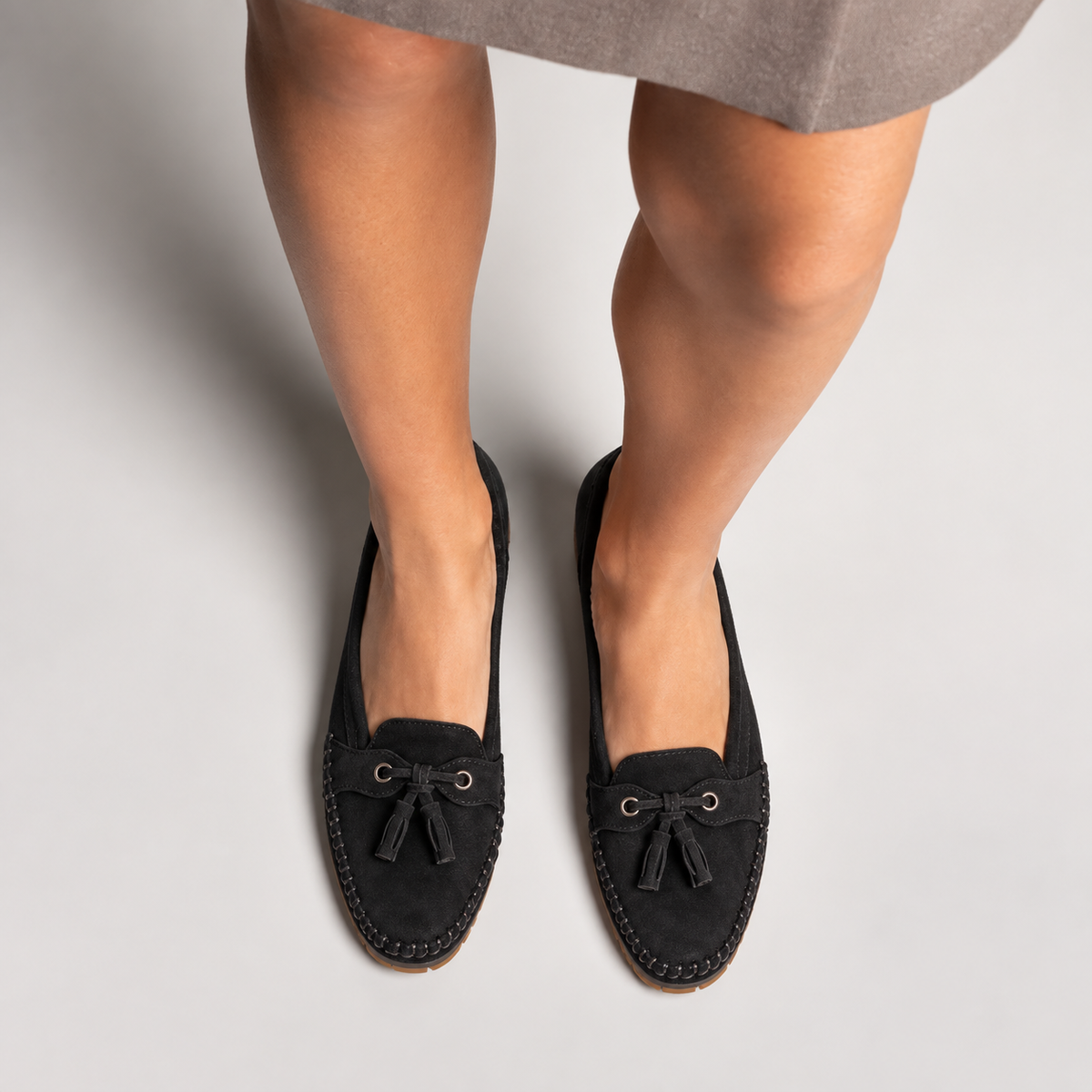 Black soft sole walking loafers worn with an elegant skirt